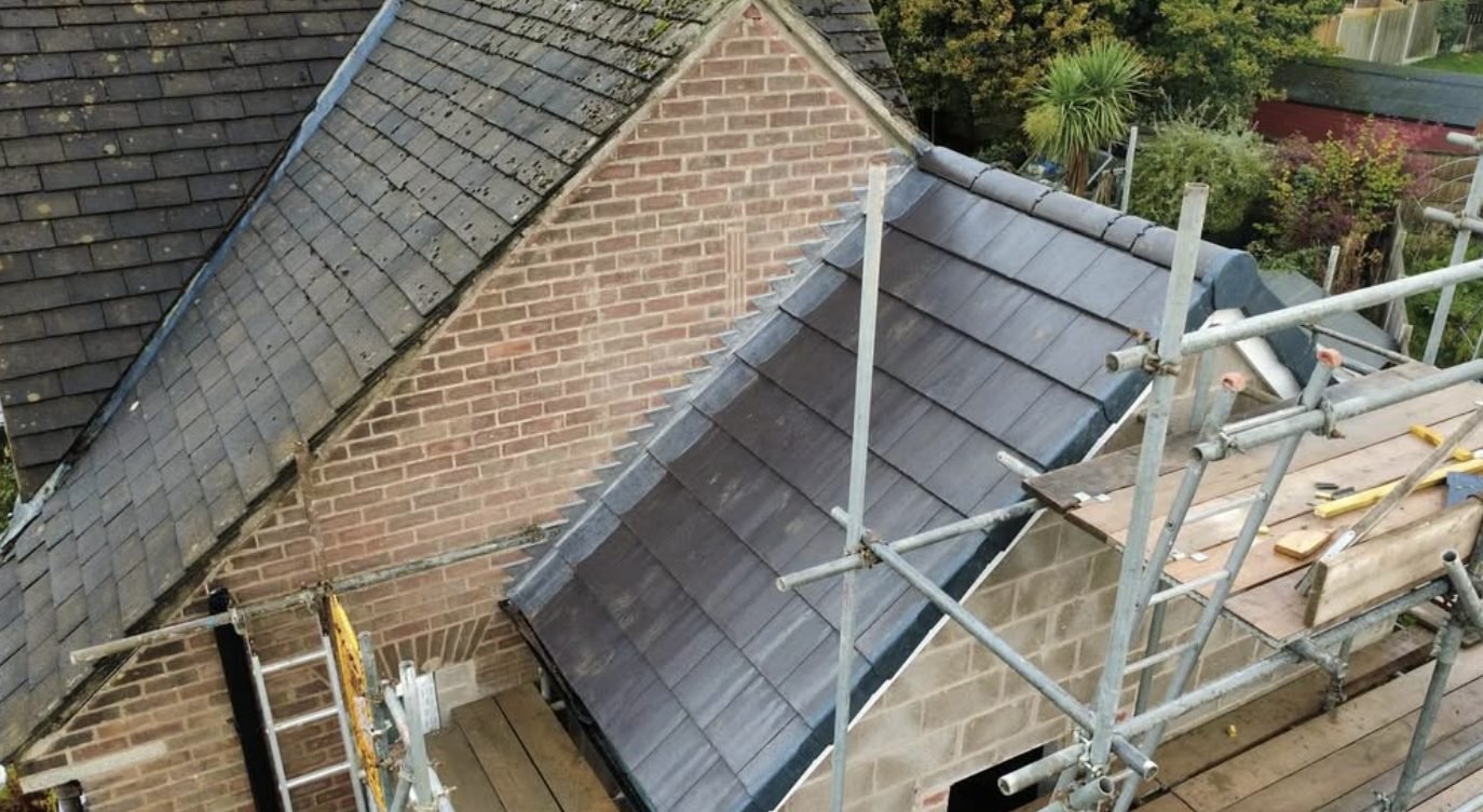 New tiled extension roof with dry verge joined to an older slate roof