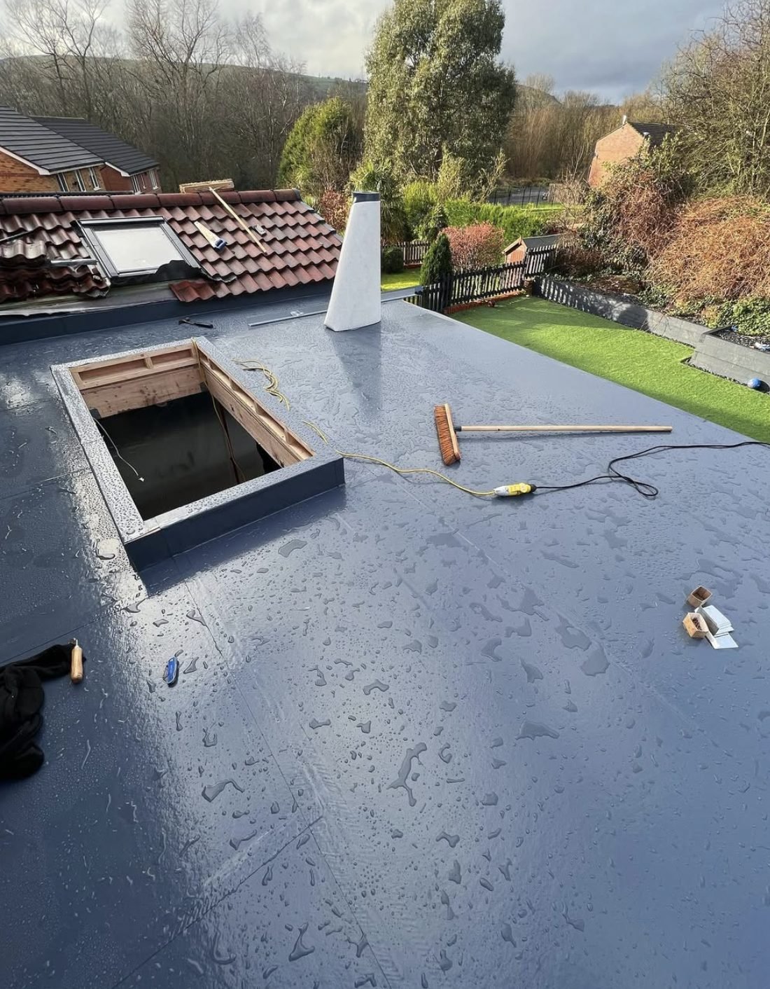 New flat roof with a formed rooflight upstand, wet after rain