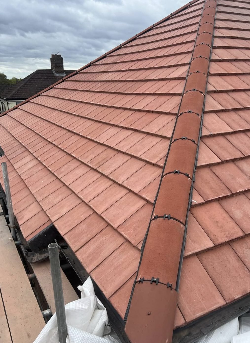 Red plain tiles with a dry-fixed hip running up the roof